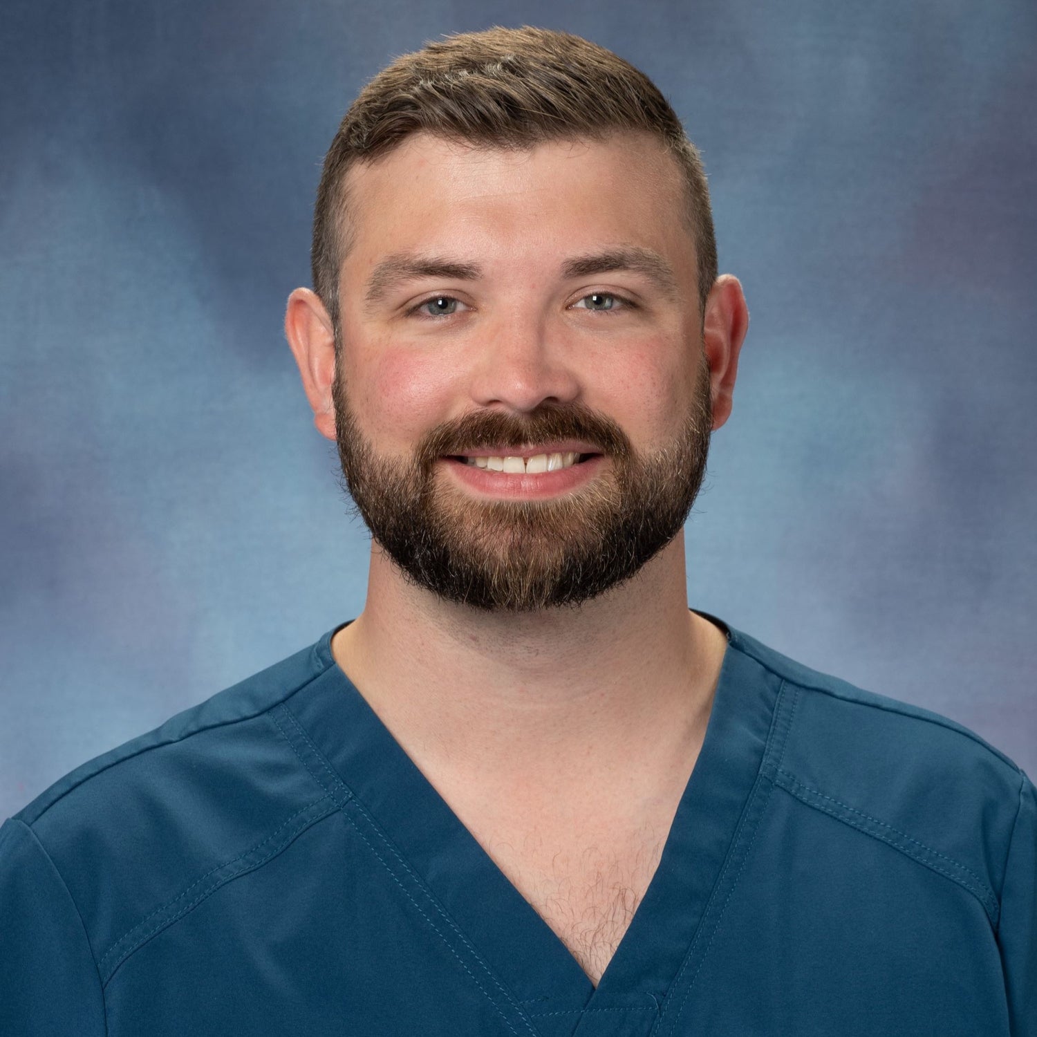 Dr. Colten J. Philpott in teal scrubs.