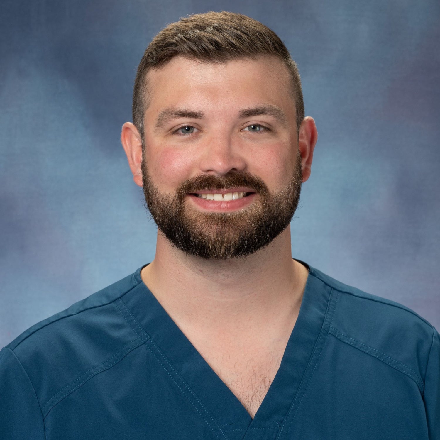 Dr. Colten J. Philpott in teal scrubs. 