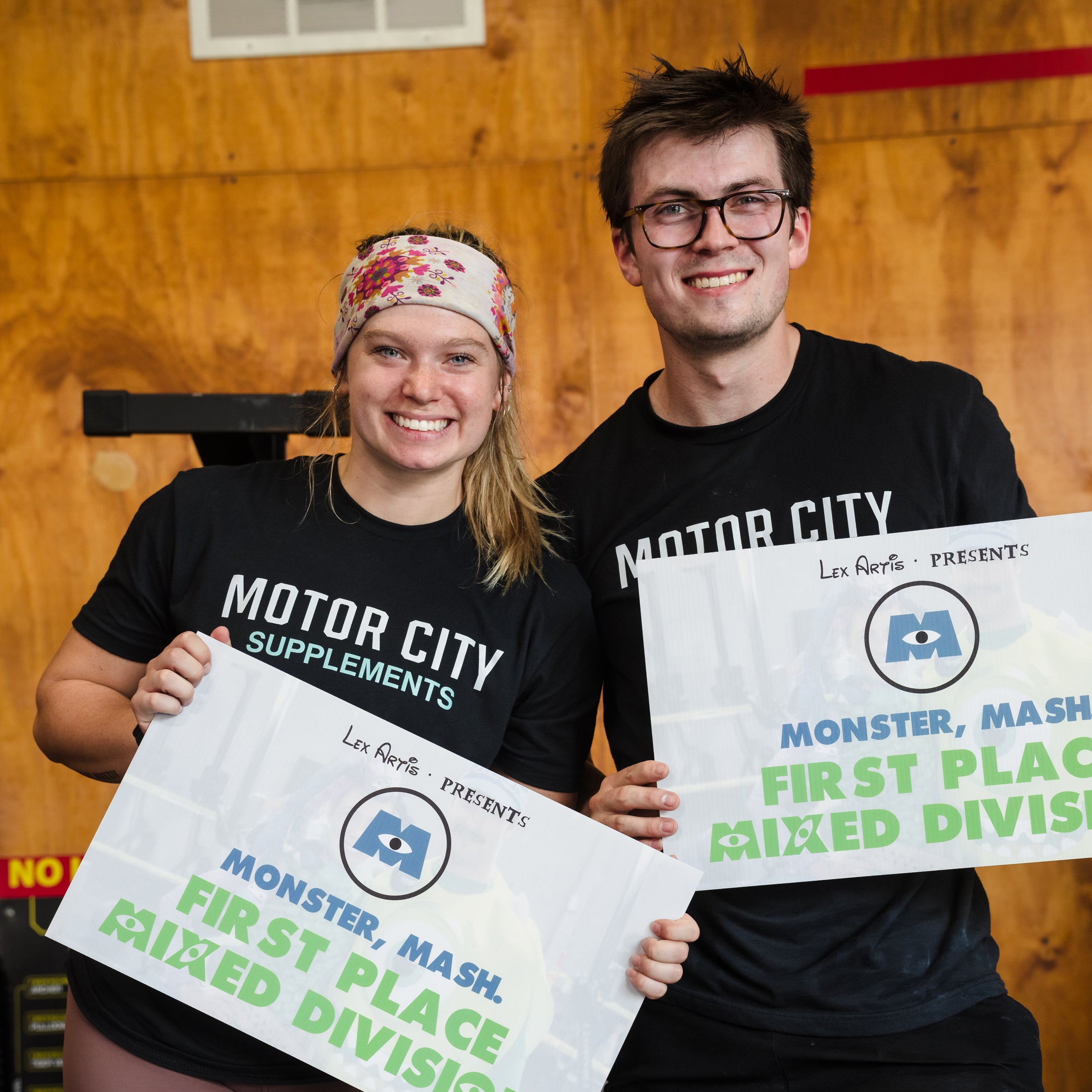 A man and a woman holding signs saying first place. 